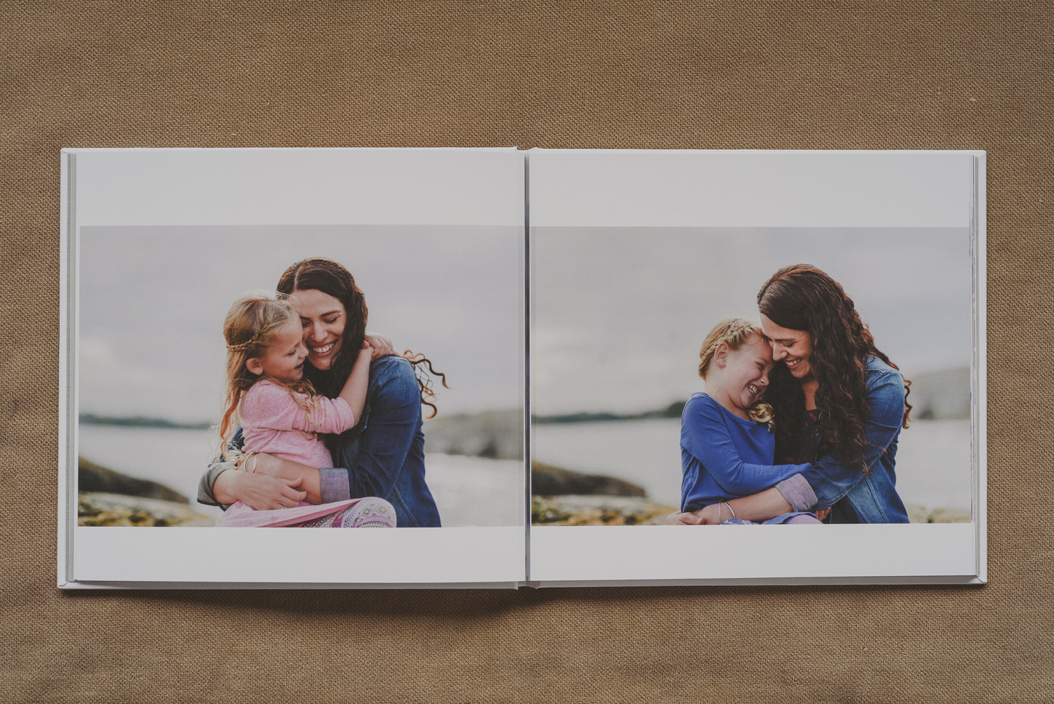 beautiful family photo book-mom snuggling young daughter at beach