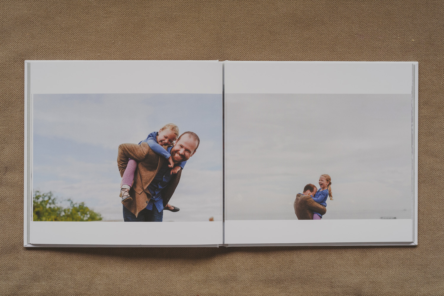 beautiful family photo book-dad piggybacking young daughter laughing