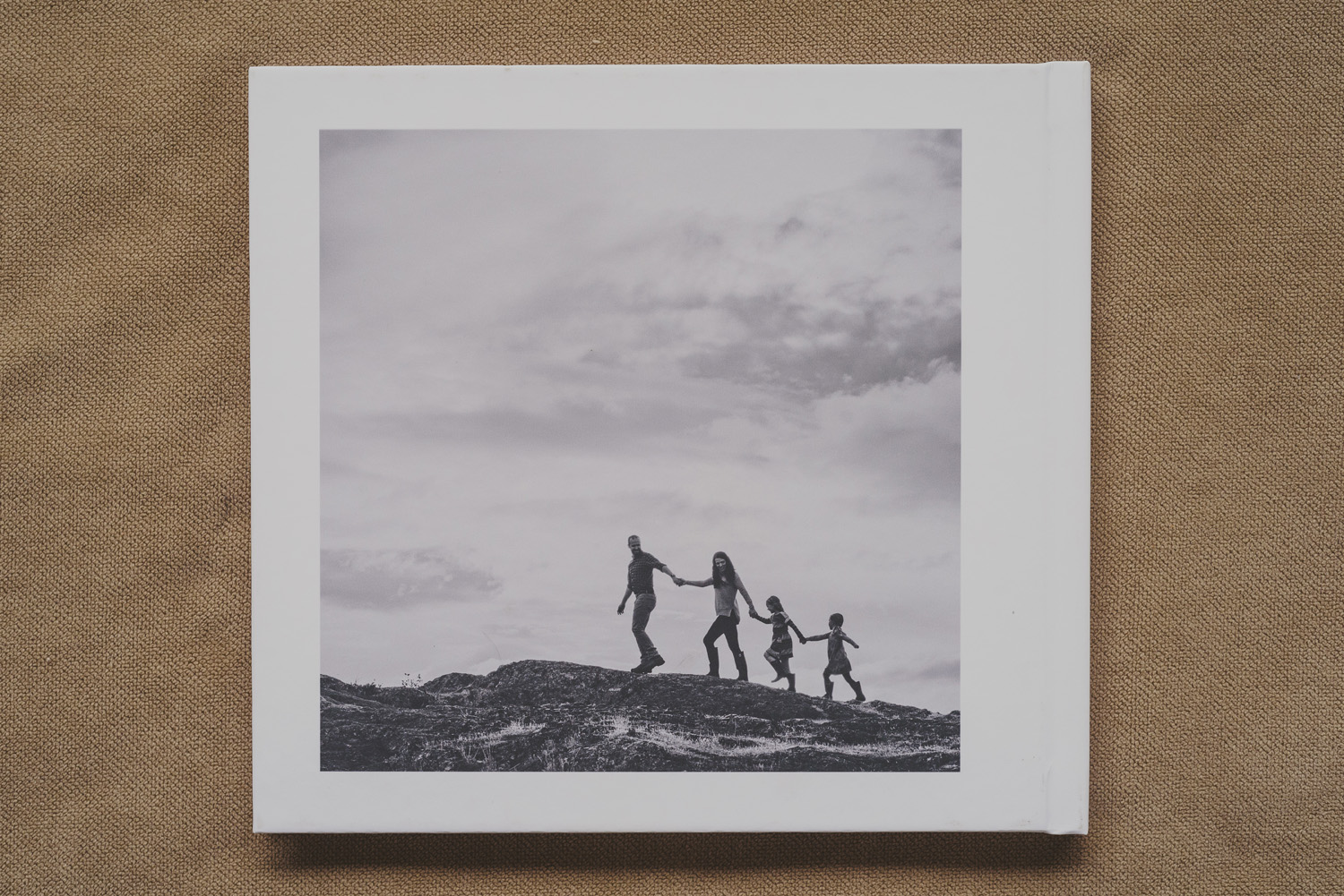beautiful family photo book-back cover of family walking along rock edge