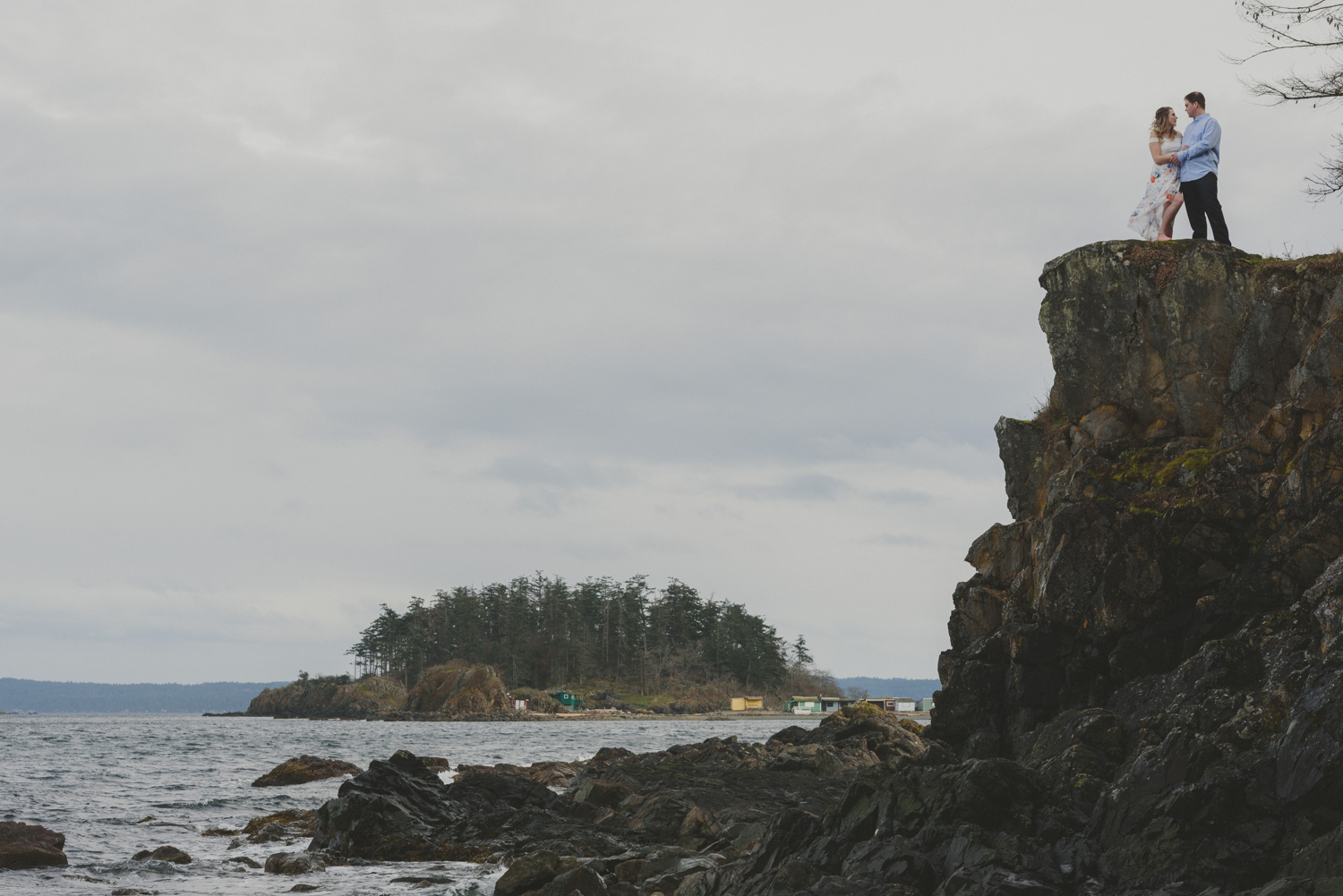 vancouver-island-bc-engagement-couple on a cliff edge overlooking the ocean