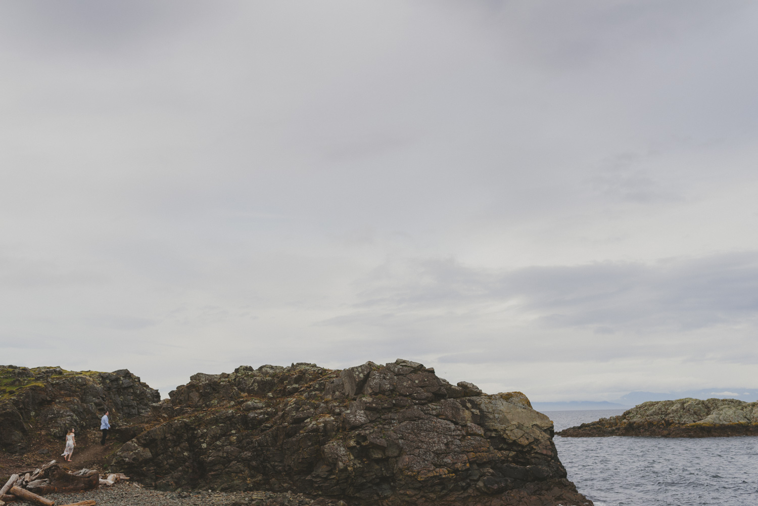 vancouver-island-bc-engagement-couple walking by a rocky beach 