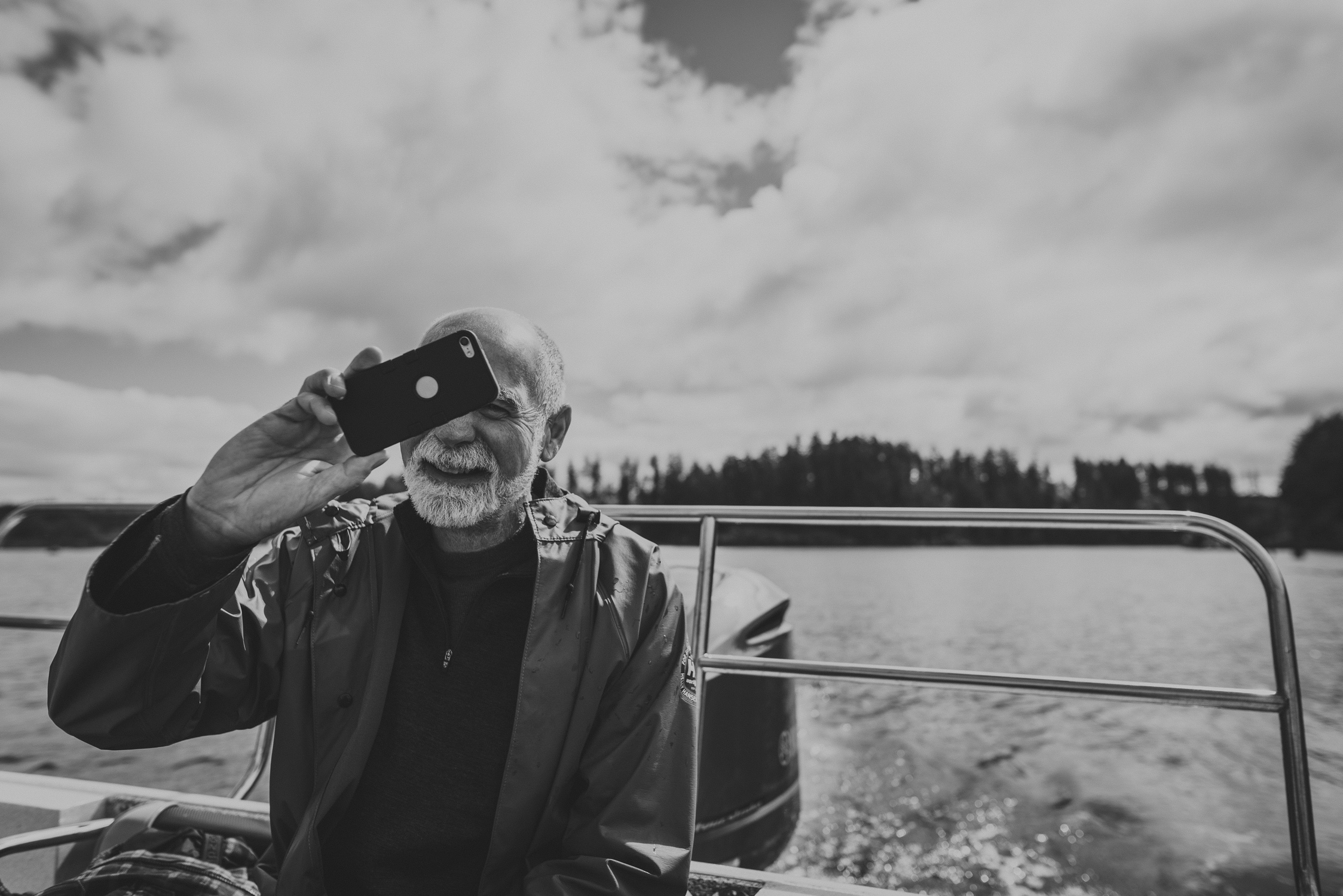 family travels - campbell river-man taking photos on the stern of a boat