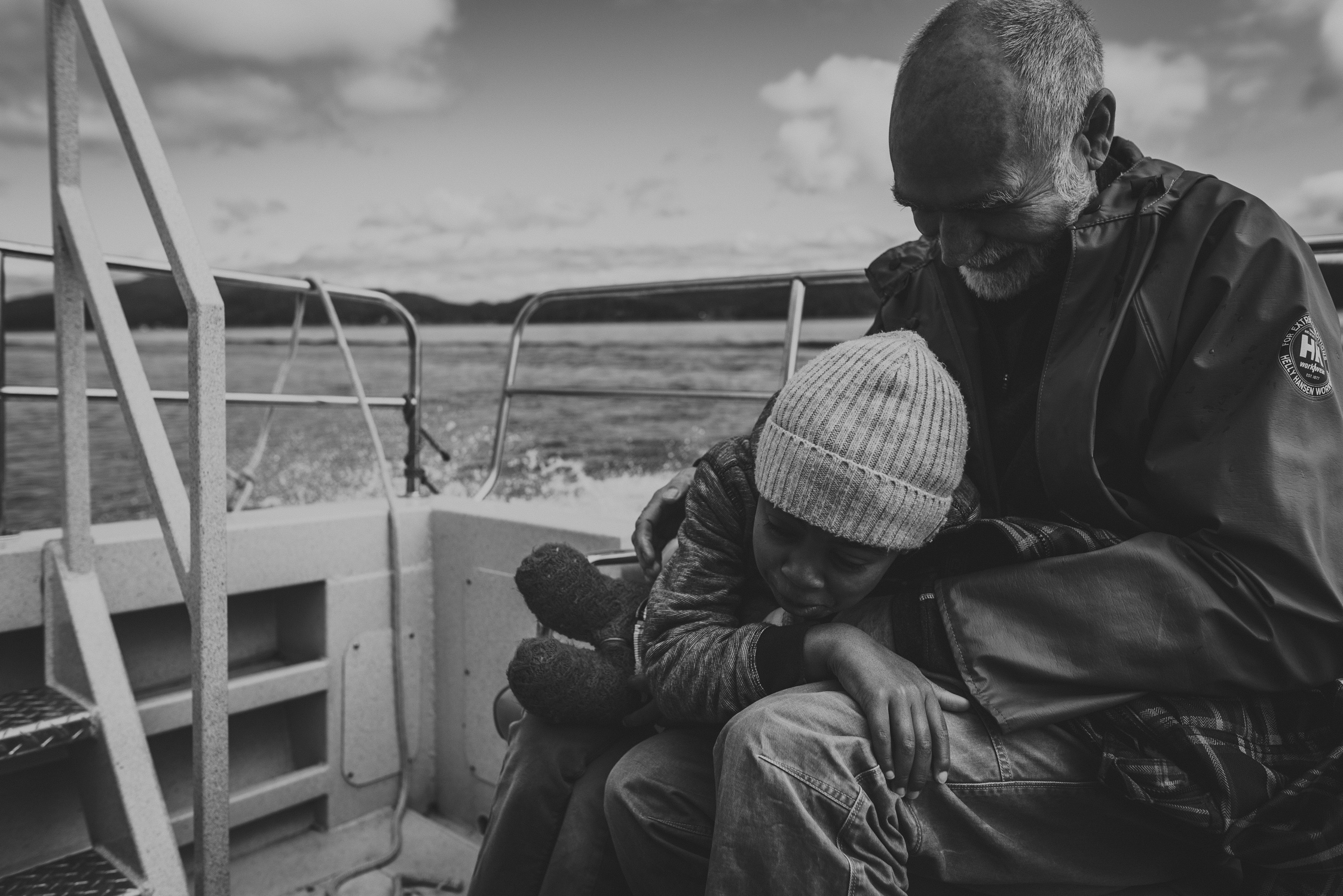 family travels - campbell river-father & daughter snuggling on the stern of a boat