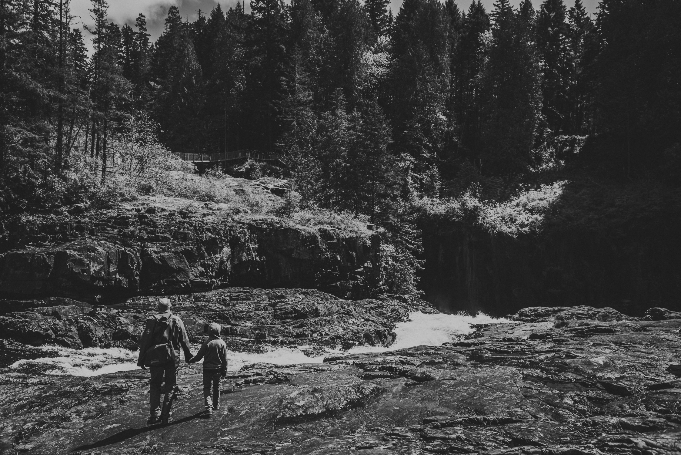 family travels - campbell river-father & kid walking beside a flowing river