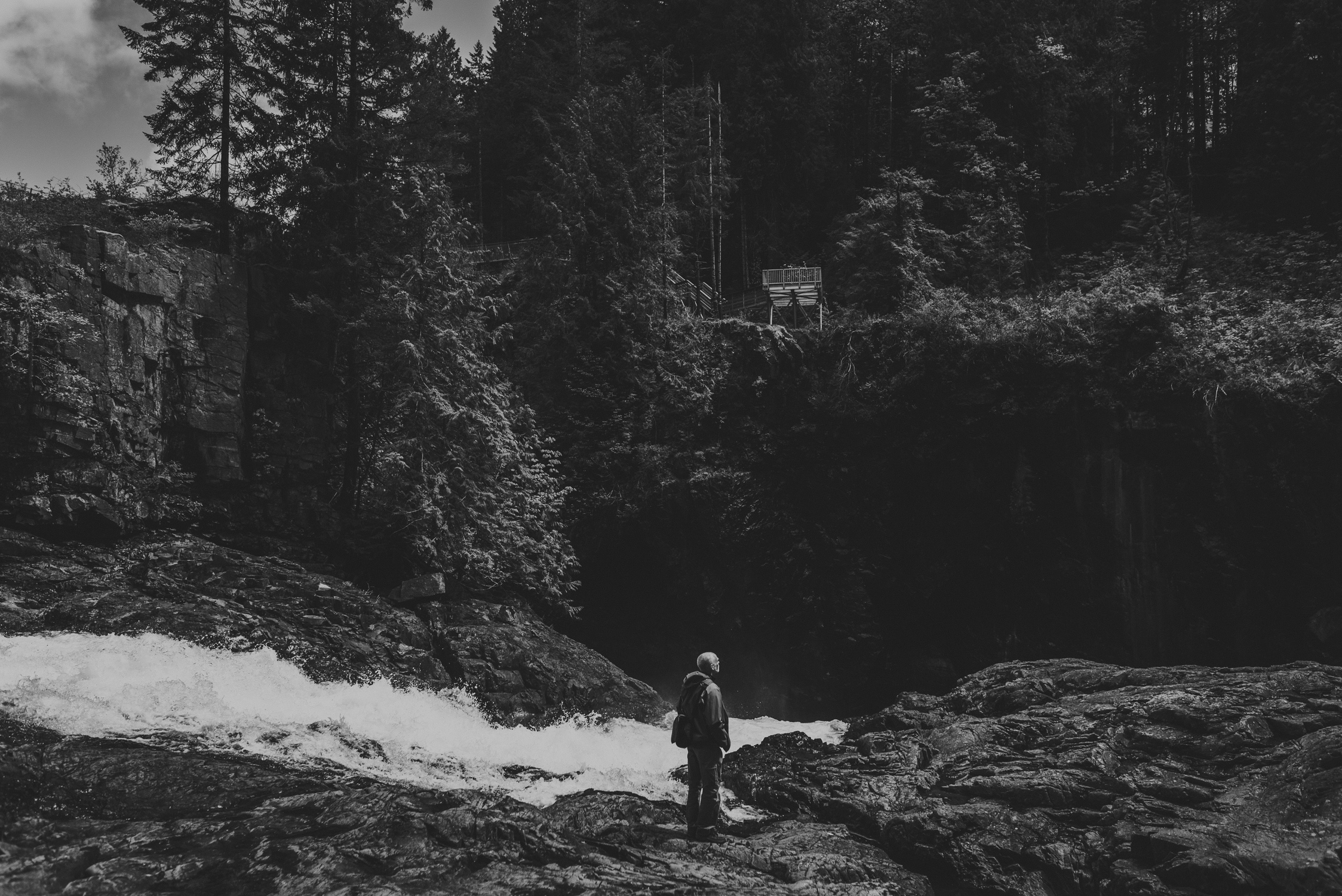 family travels - campbell river-man standing beside a flowing river