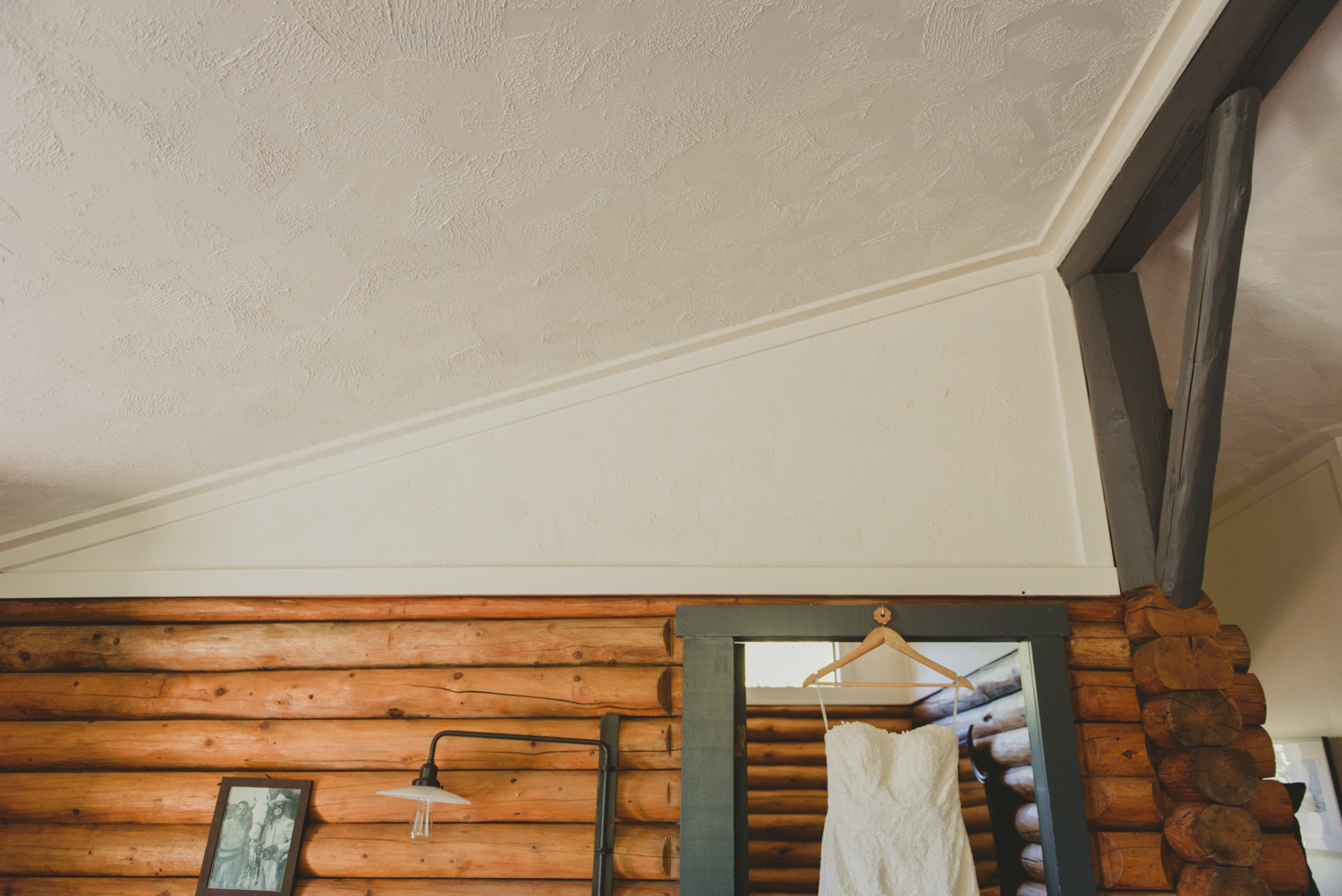 wedding dress hanging in rustic cabin at bodega ridge galiano island