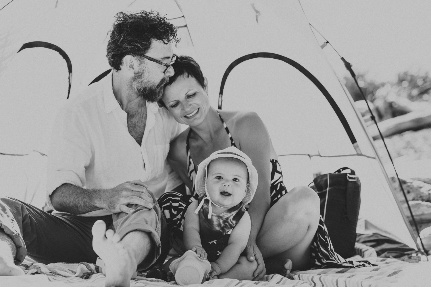 family of 3 under a beach tent on hornby island