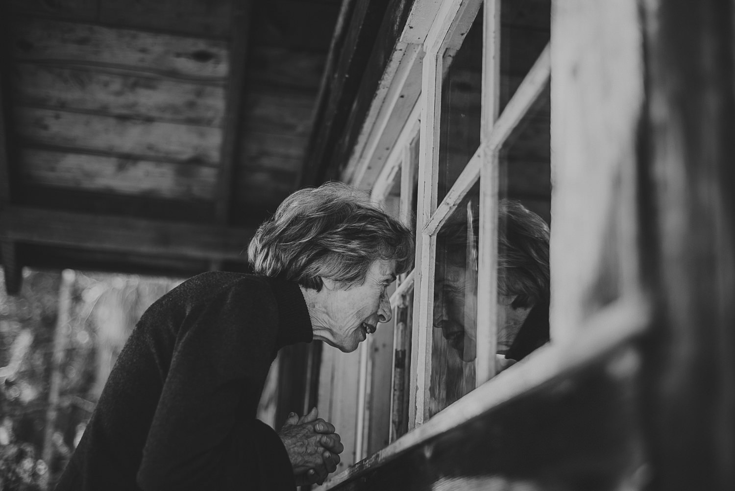 woman looking in a window of a cabin at overbury resort thetis island wedding - 