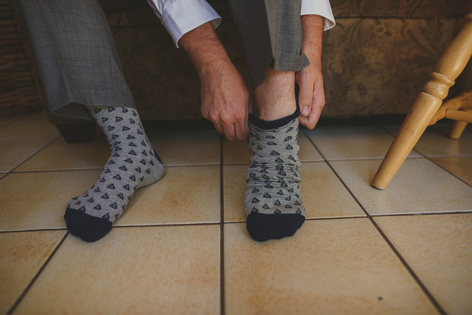 groom putting on nautical socks at overbury resort thetis island wedding - 