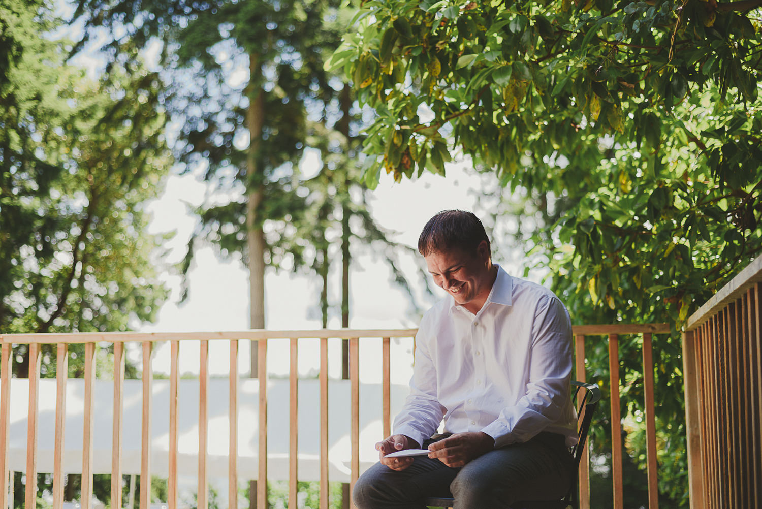 groom reading letter & smiling at overbury resort thetis island wedding 