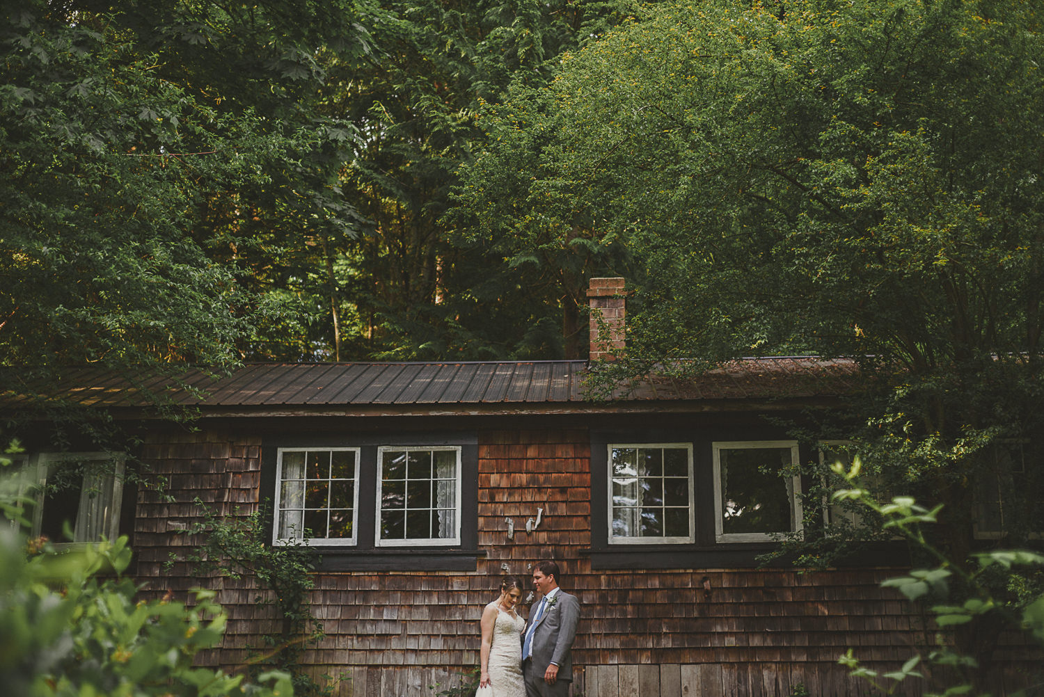 bride & groom in front of rustic cabin at overbury resort thetis island wedding 