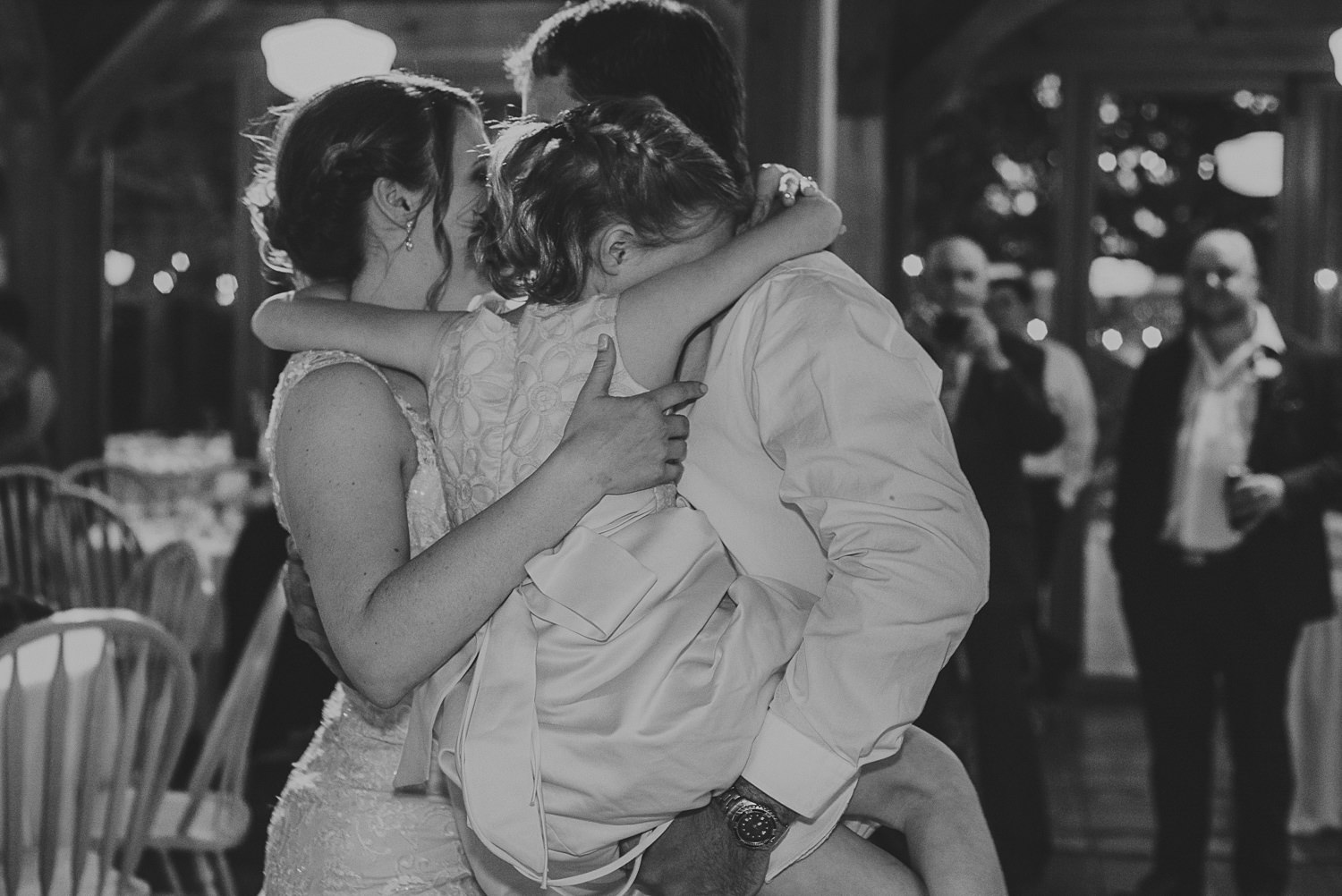 bride & groom hugging child at overbury resort thetis island wedding 