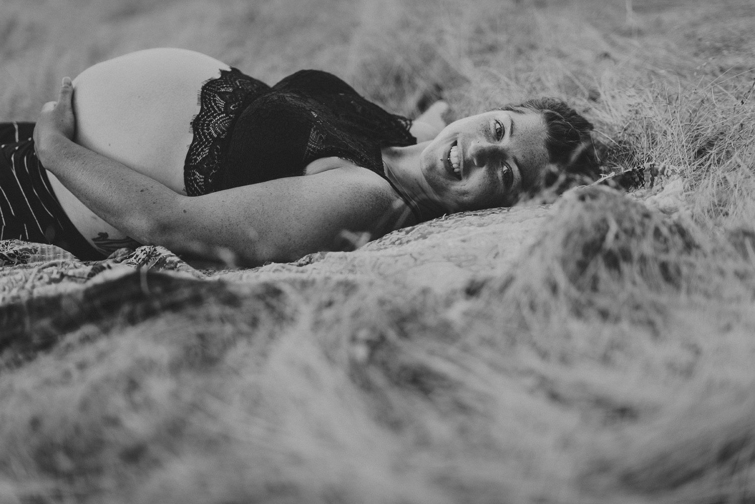 young happy pregnant woman lying on the grass-hornby island lifestyle maternity session