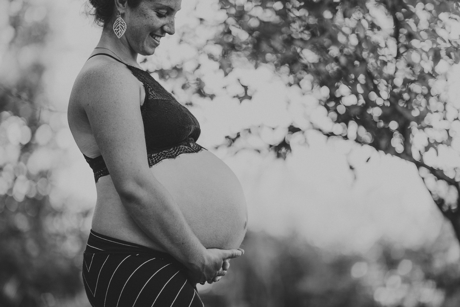 young happy pregnant woman smiling holding her belly-hornby island lifestyle maternity session