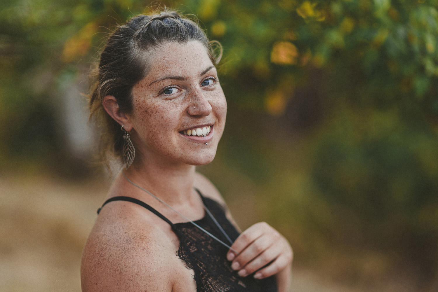 young beautiful woman with summer tan & freckles smiling at the camera-hornby island lifestyle maternity session