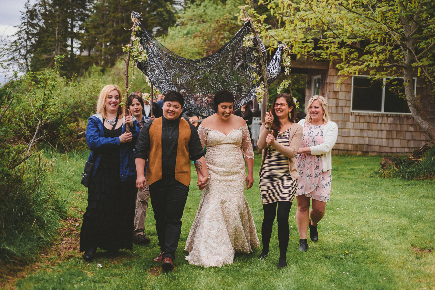 lgbtq jewish pagan metis wedding at sea breeze lodge on hornby island walking under the chuppah