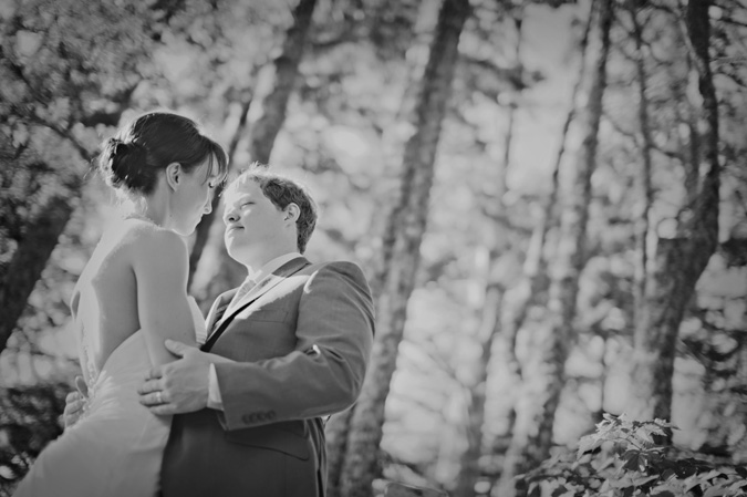 bride and groom embracing in a forest