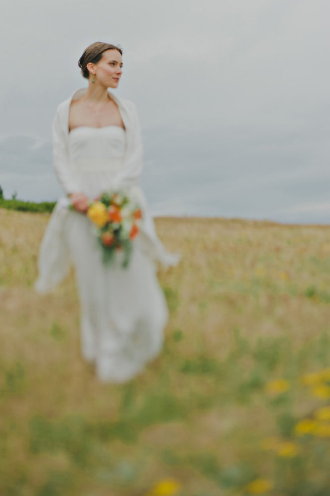bride holding orange and yellow bouquet