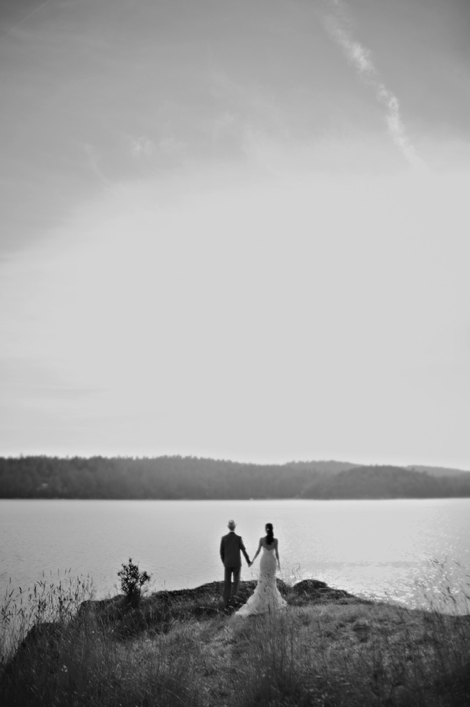 bride and groom holding hands at the edge of the ocean