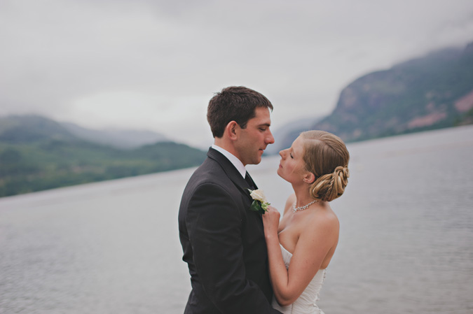 bride and groom embrace near a lake