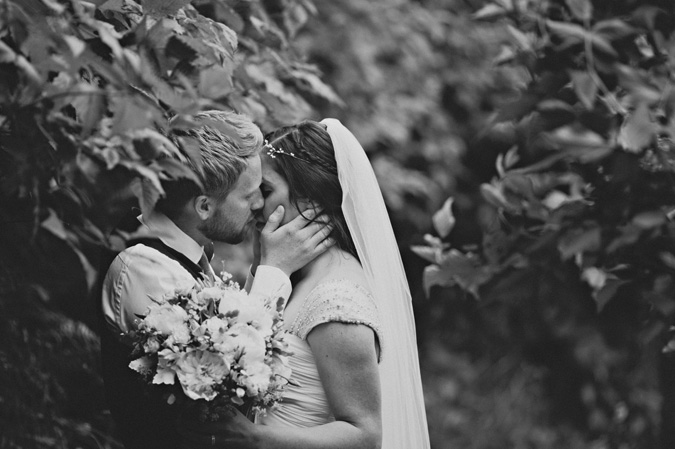 bride and groom kiss in a forest