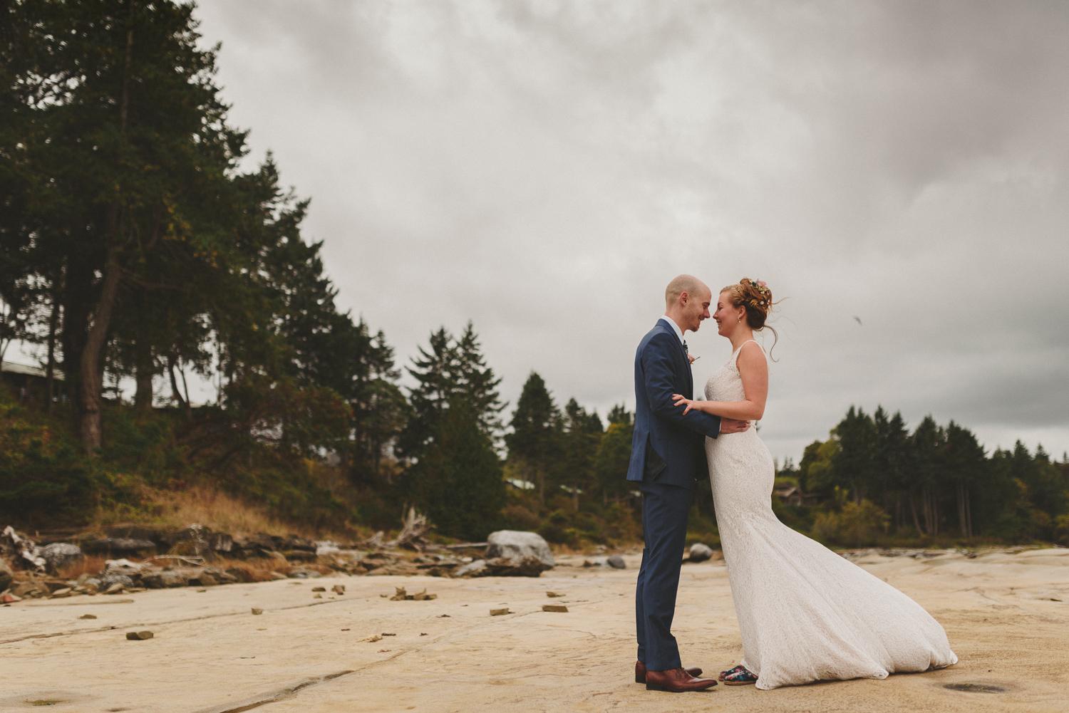 bride & groom on the beach with wind blowing