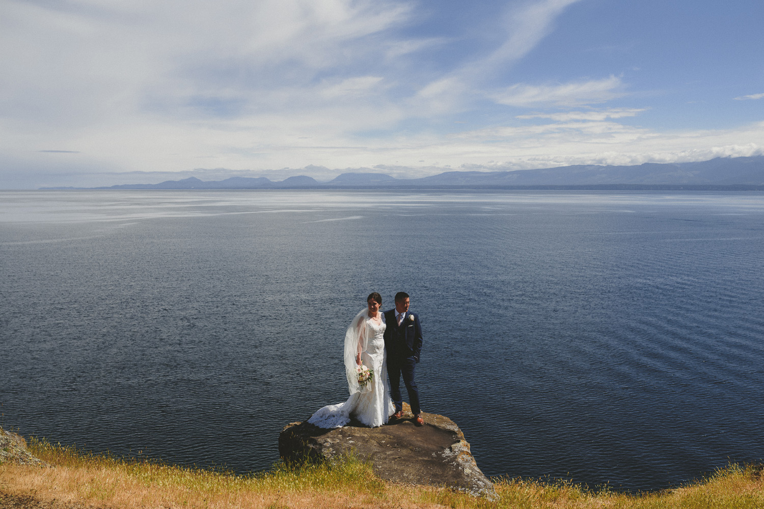 bride & groom at the edge of a cliffe overlooking the ocean
