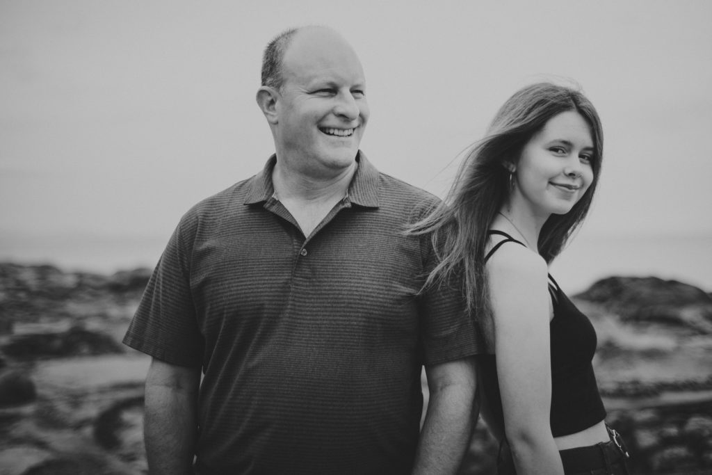 black & white photo of a dad & his teenage daughter laughing