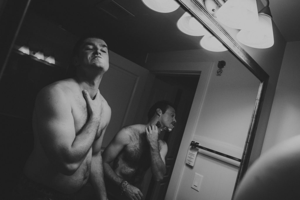 guys shaving in a hotel room bathroom