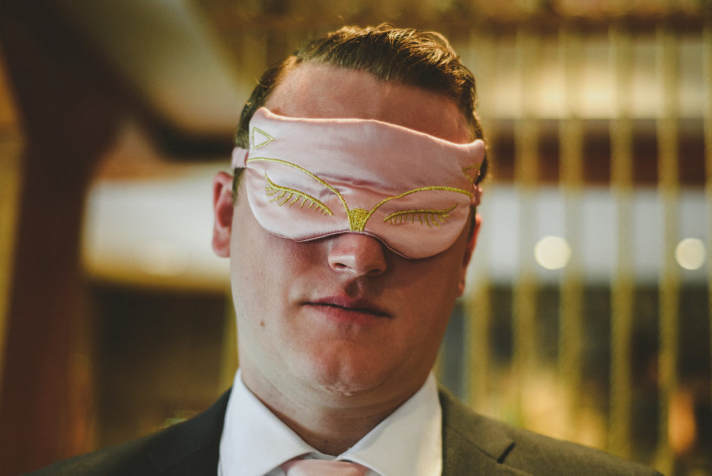 close-up of a groom blindfolded 