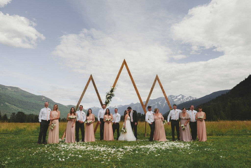 wedding party in front of their alter with fields & mountains behind them