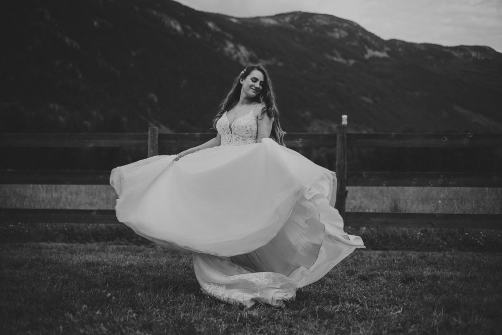 bride twirling in her wedding dress with mountains behind her