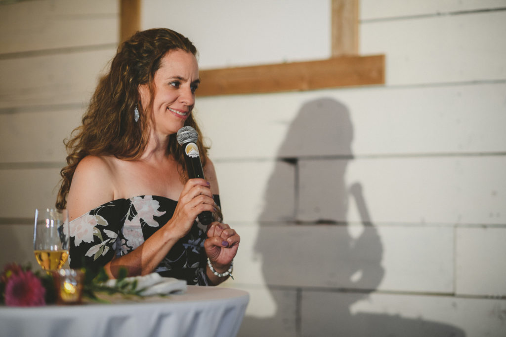 woman giving a toast to a wedding couple smiling
