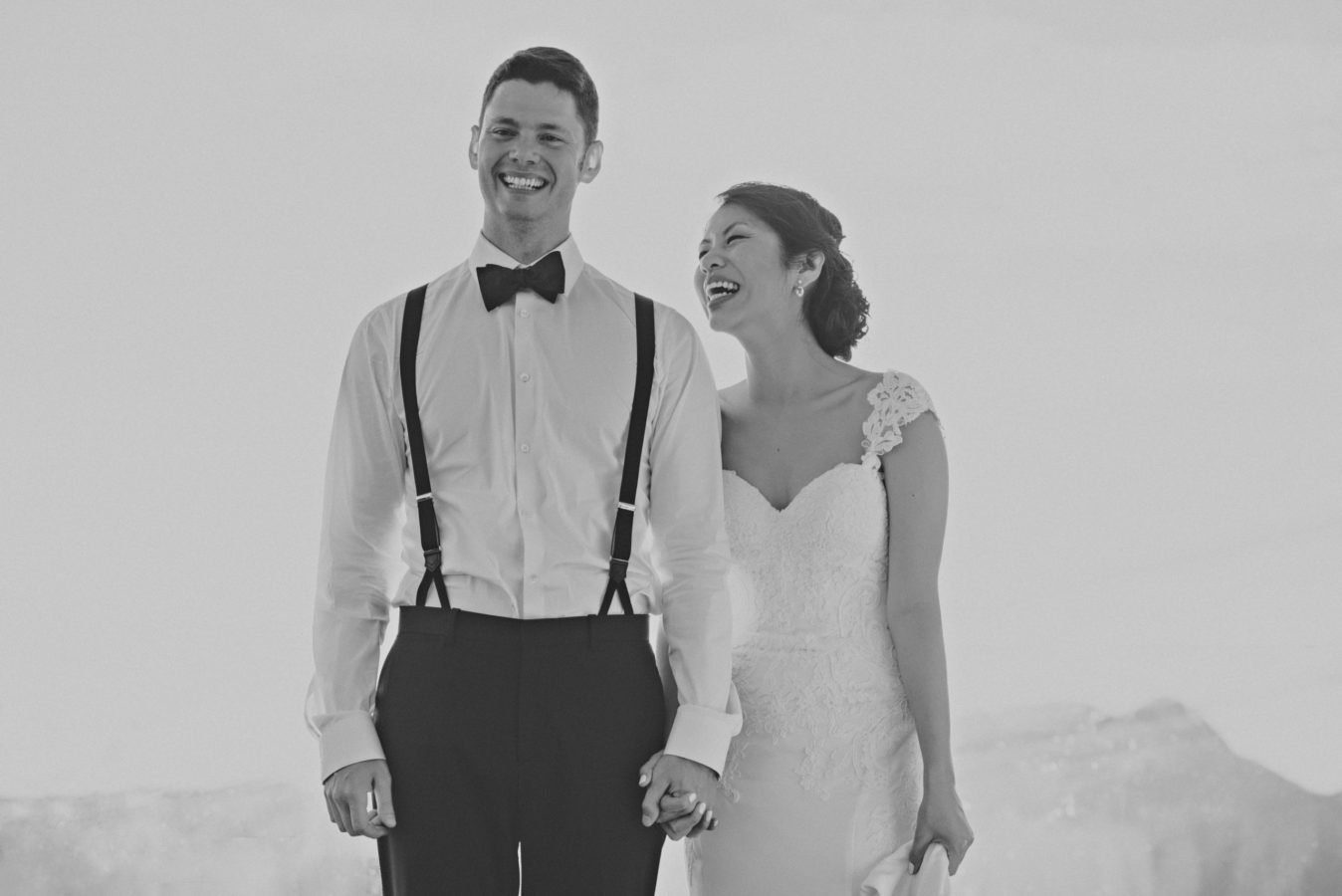 mixed race wedding couple holding hands and laughing