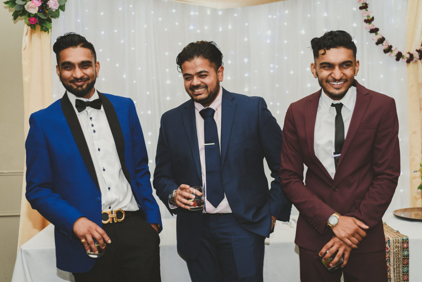 three well dressed men laughing at a wedding