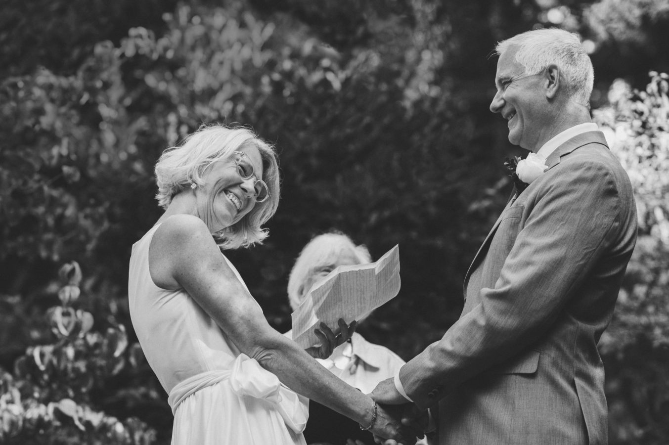 older bride and groom laughing during their wedding vows