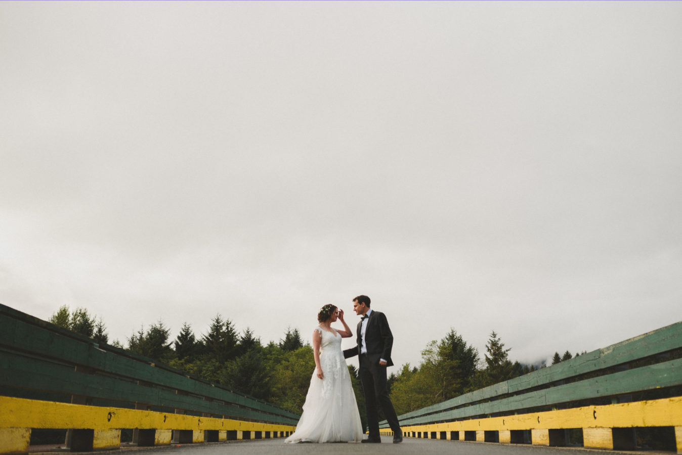 bride and groom on a bridge looking at one another