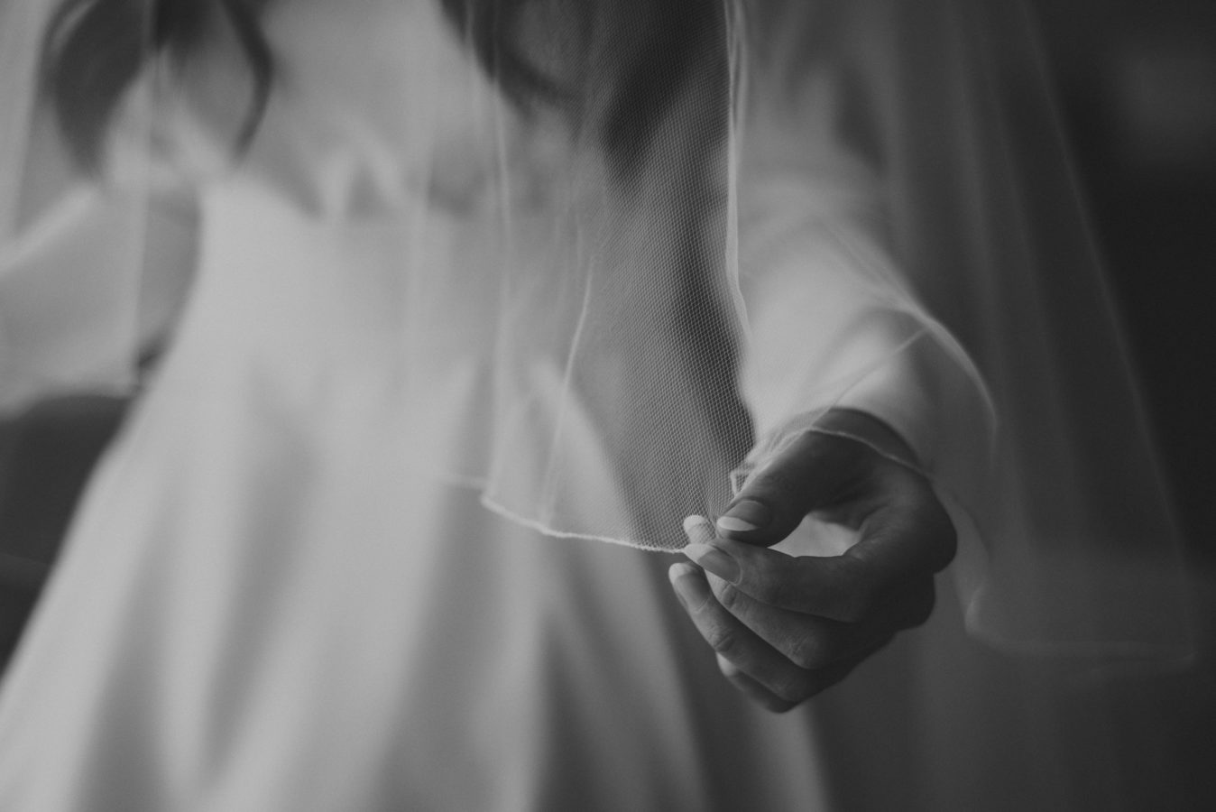 close up of a bride's hand holding her wedding veil