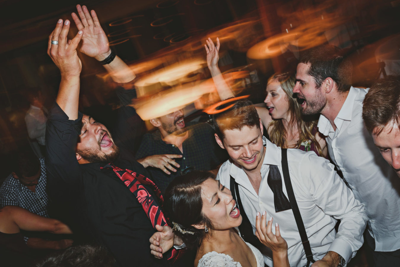 mixed race couple and friends laughing and partying on the dance floor