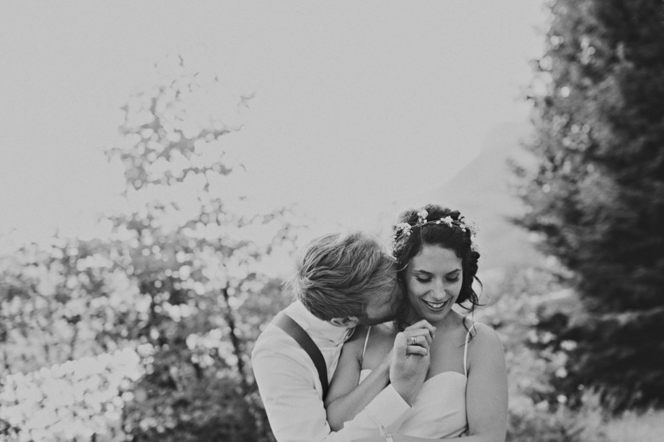 groom kissing his bride while embracing on their wedding day