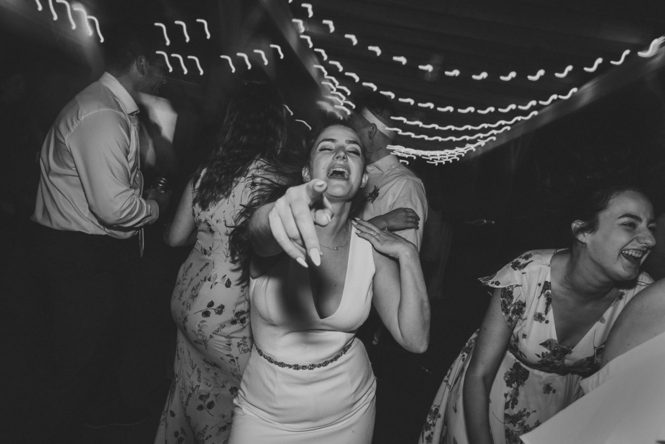 bride dancing and pointing at the camera on the dance floor on her wedding day