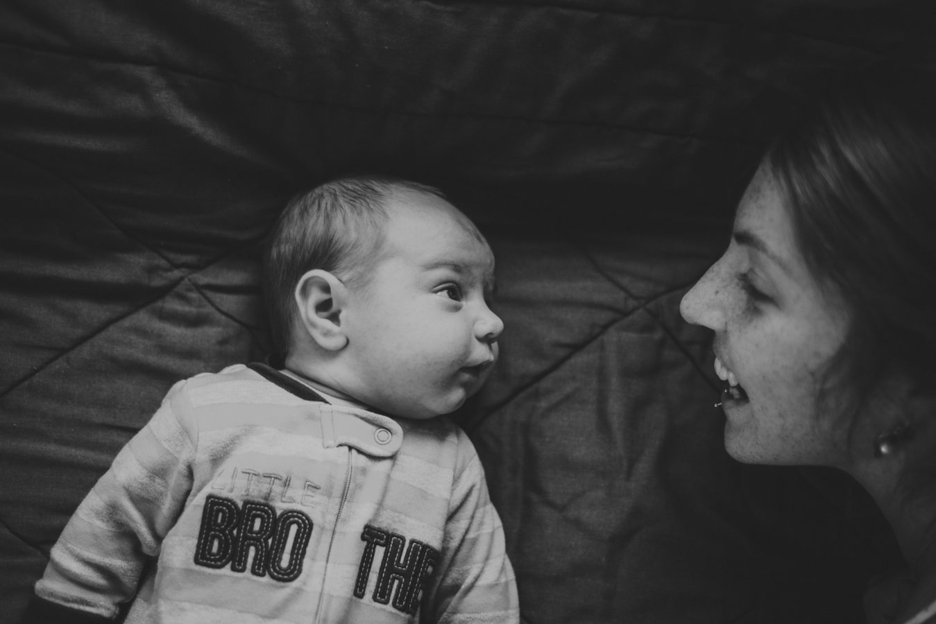 mom and baby lying looking at each other