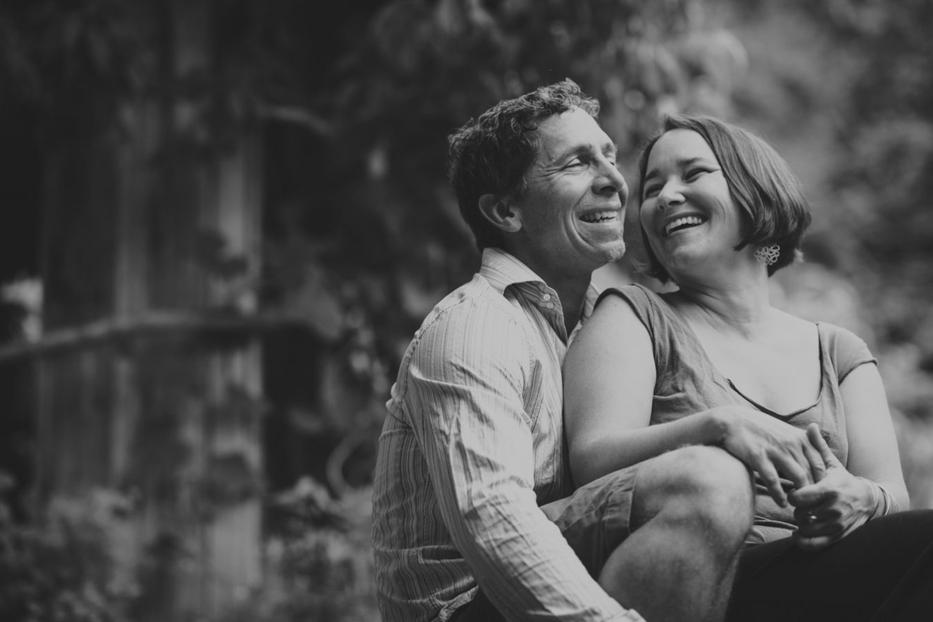 husband and wife sitting snuggled together and laughing
