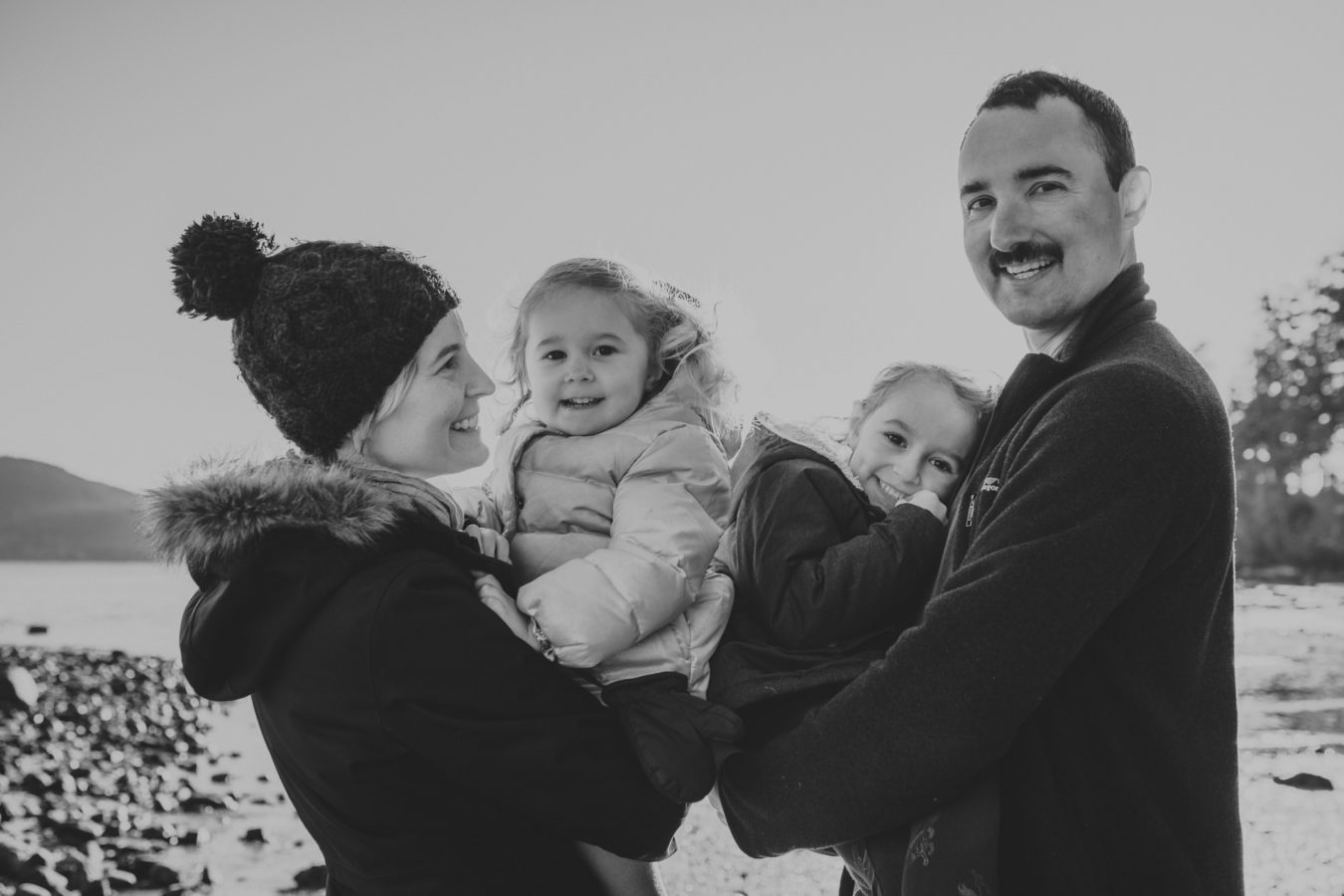 mom, dad and their two kids laughing and smiling