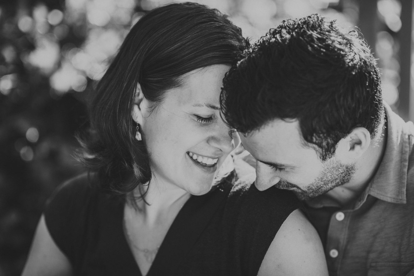 man kissing his wife's shoulder in a sweet intimate moment