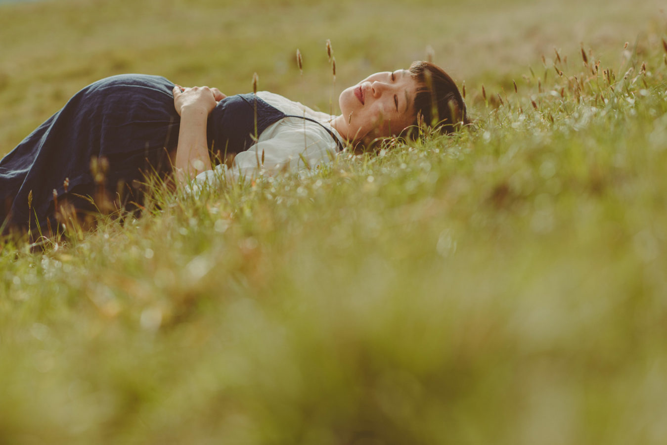 pregnant woman lying in the tall grass