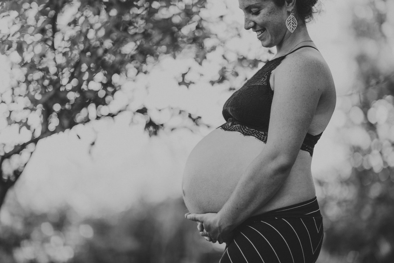 close up of a smiling pregnant woman's belly