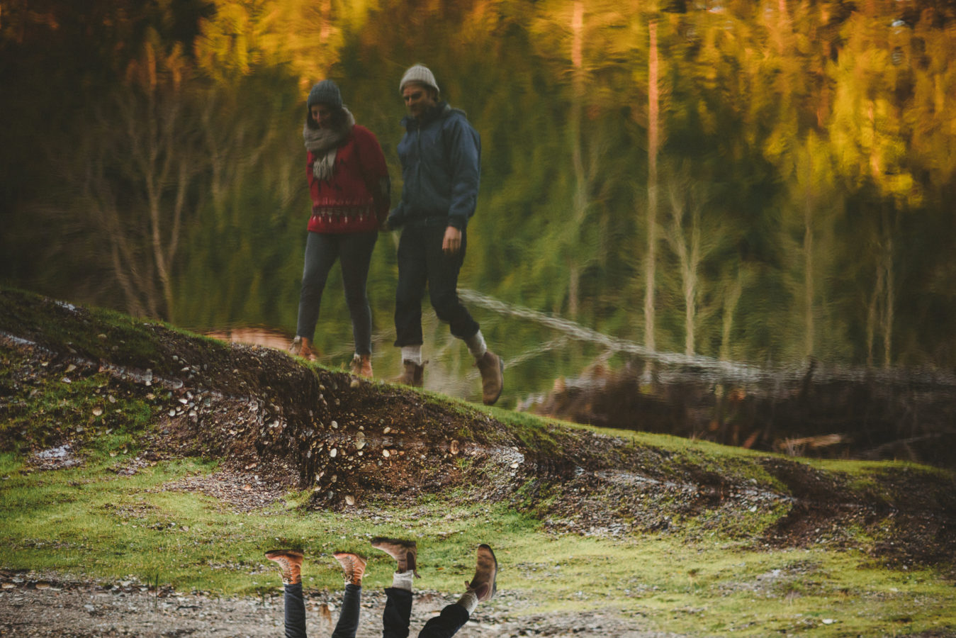 upside down photo of a couple walking along the edge of a pond