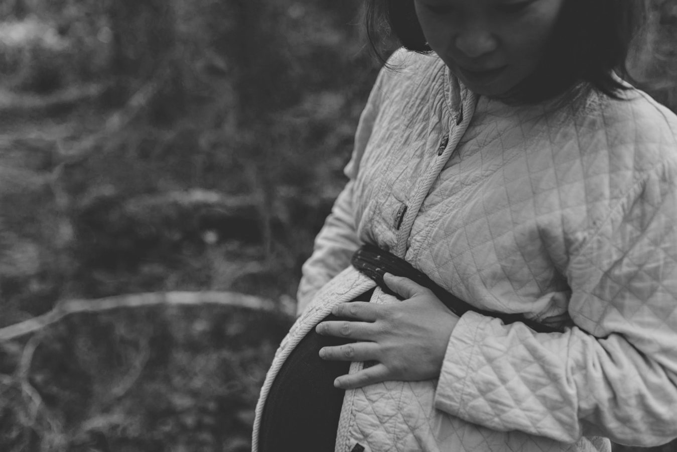 close up of a woman holding her pregnant belly
