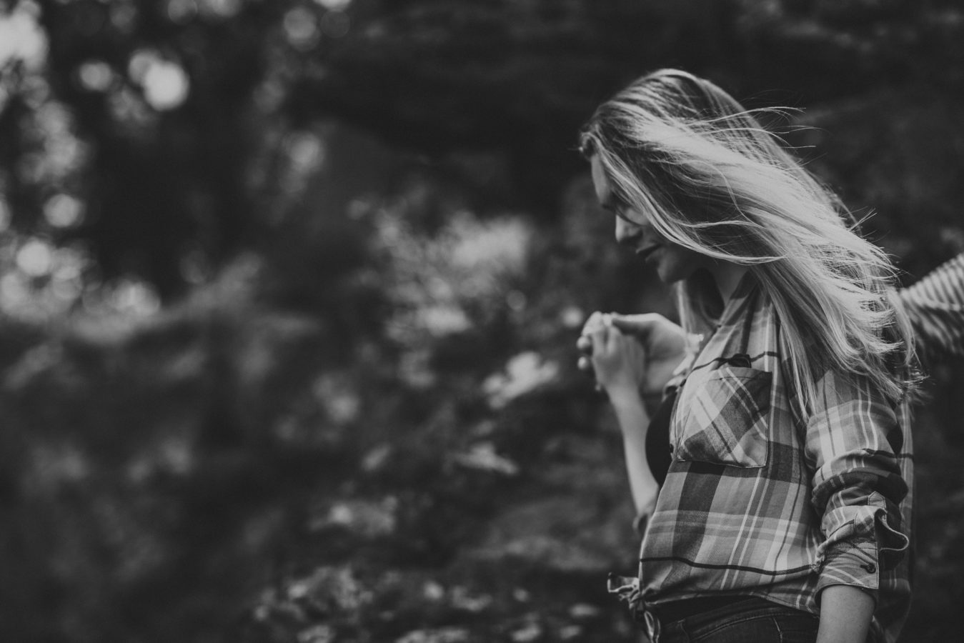 detail of a woman's hair as she walks holding her partner's hand